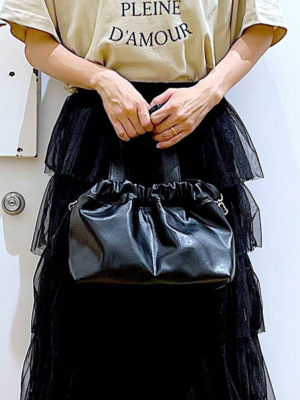 ブラック系のサンダル、ブラック系のショルダーバッグ、ブラック系のスカートを着用したレディースの夏コーディネートの9枚目の写真