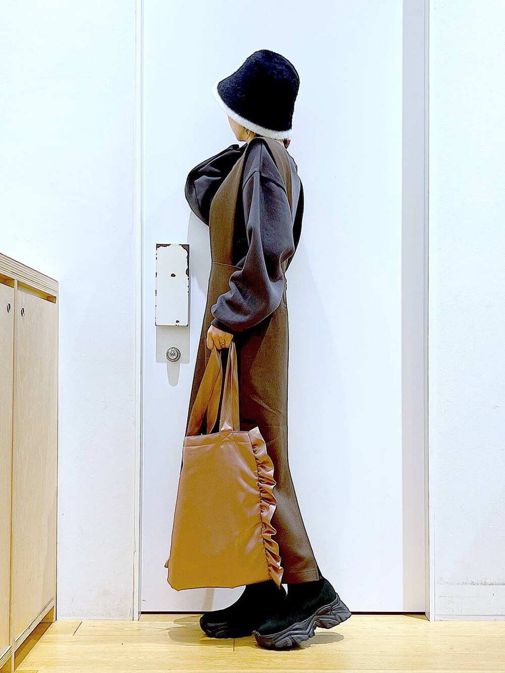 ブラック系のブーツ、ブラウン系のサロペット/オーバーオール、ピンク系のトートバッグを着用したレディースの冬コーディネートの3枚目の写真