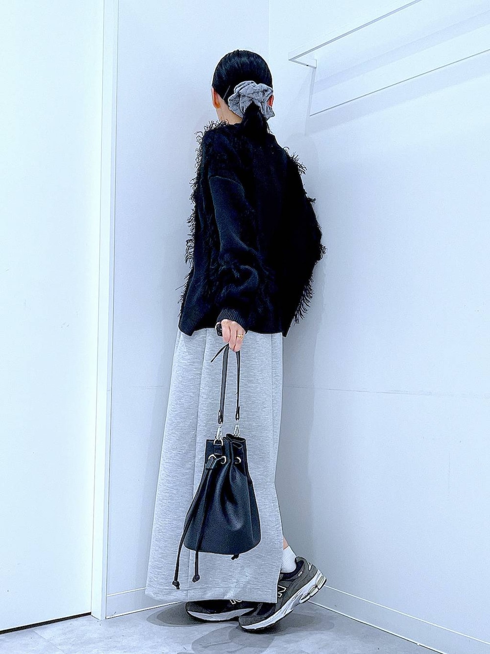 グレー系のスカート、ブラック系のショルダーバッグ、ブラック系のカーディガン/ボレロを着用したレディースの春コーディネートの3枚目の写真