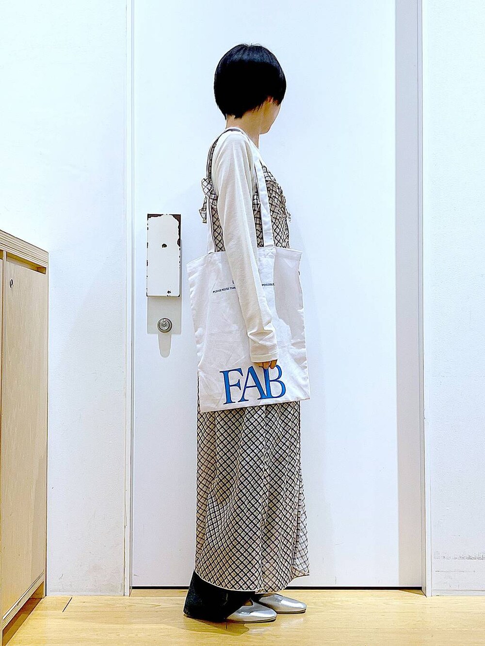 ブルー系のデニムパンツ、シルバー系のパンプス、ホワイト系のTシャツ/カットソーを着用したレディースの春コーディネートの4枚目の写真