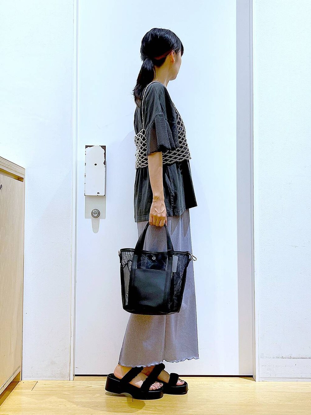 パープル系のスカート、ブラック系のサンダル、ブラック系のトートバッグを着用したレディースの夏コーディネートの4枚目の写真