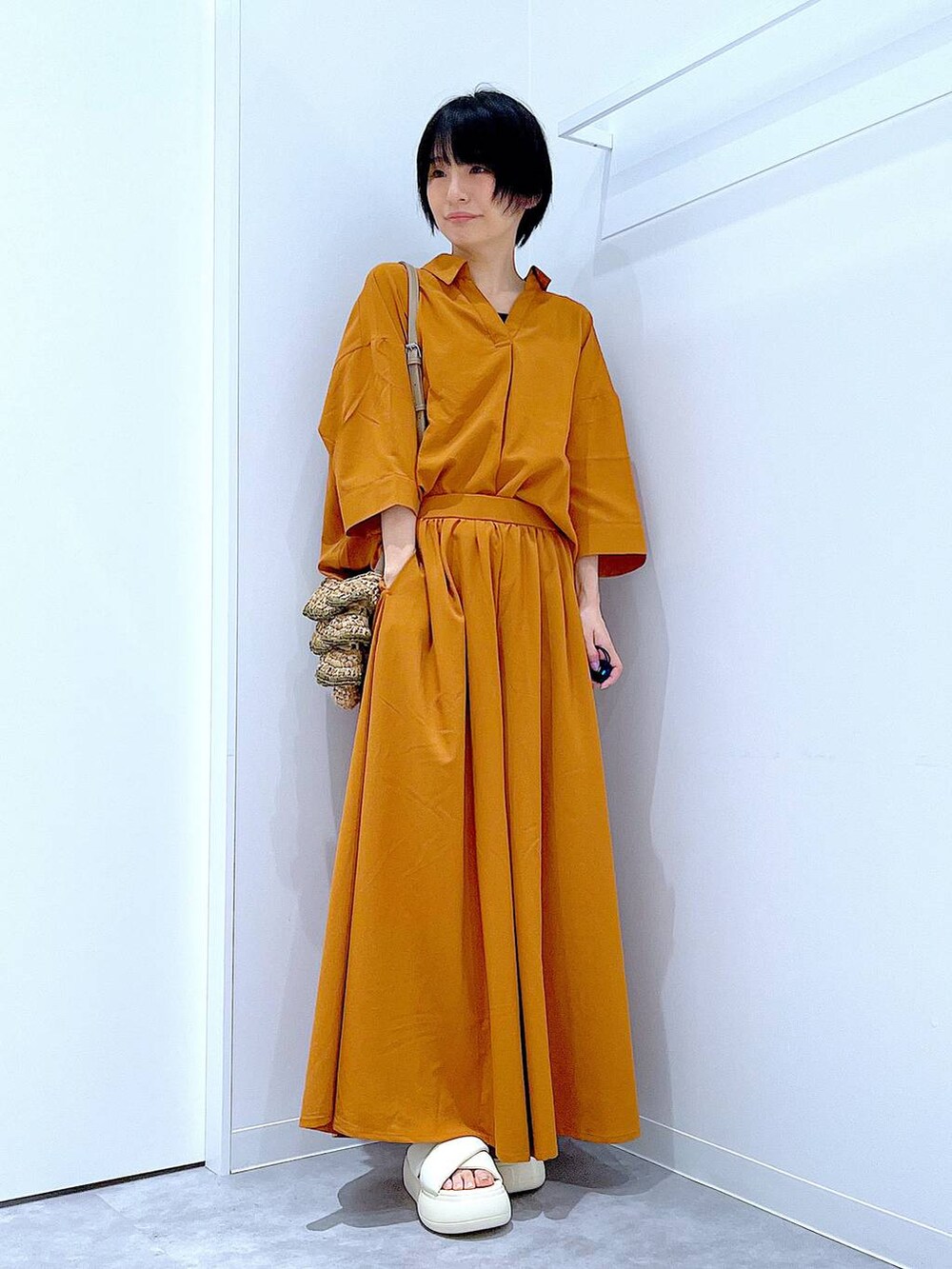 ベージュ系のショルダーバッグ、ホワイト系のサンダル、ブラウン系のその他パンツを着用したレディースの夏コーディネートの2枚目の写真