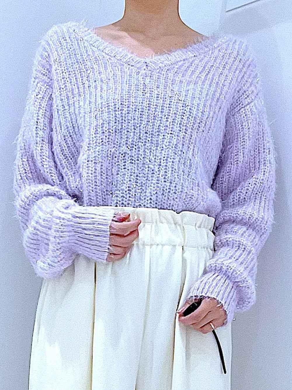 ブラック系のブーツ、ホワイト系のショルダーバッグ、パープル系のニット/セーターを着用したレディースの冬コーディネートの7枚目の写真