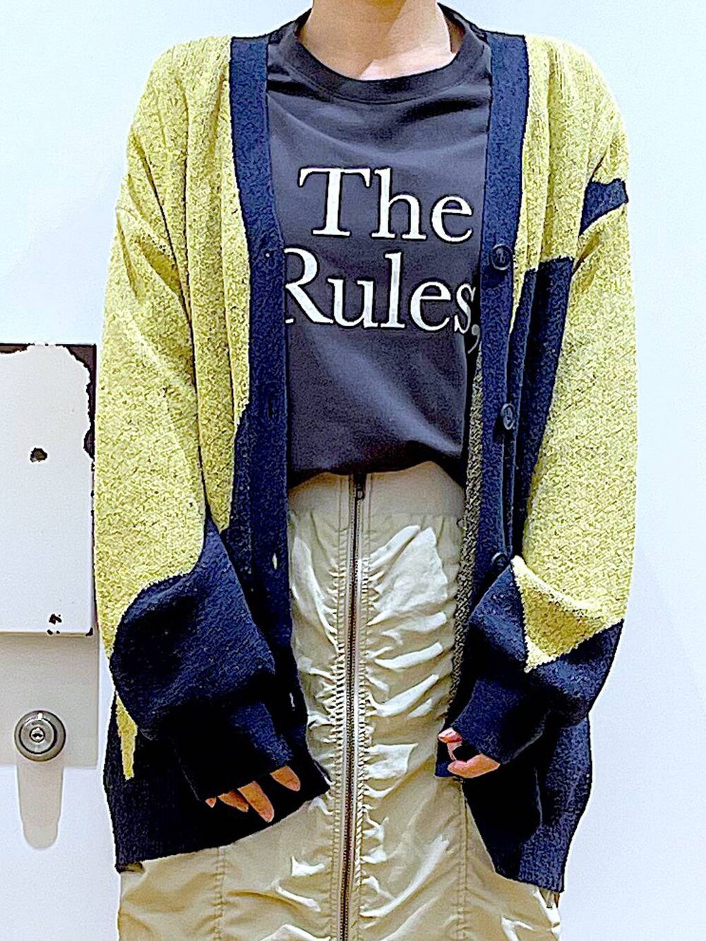 ベージュ系のスカート、シルバー系のショルダーバッグ、ブラック系のスニーカーを着用したレディースの春コーディネートの7枚目の写真