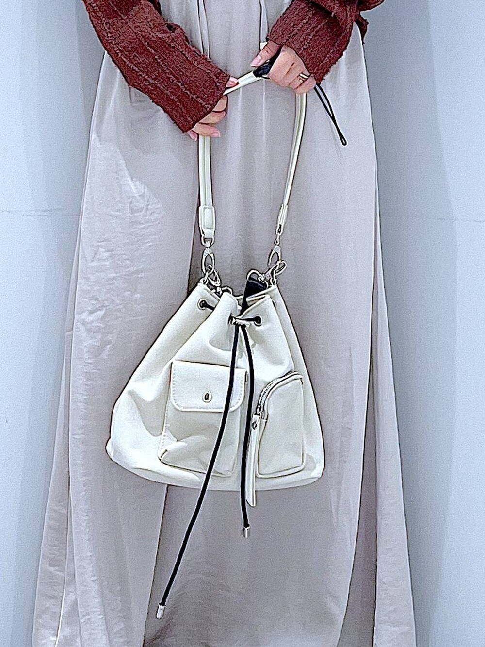 ホワイト系のローファー、ホワイト系のショルダーバッグ、ベージュ系のスカートを着用したレディースの秋コーディネートの9枚目の写真