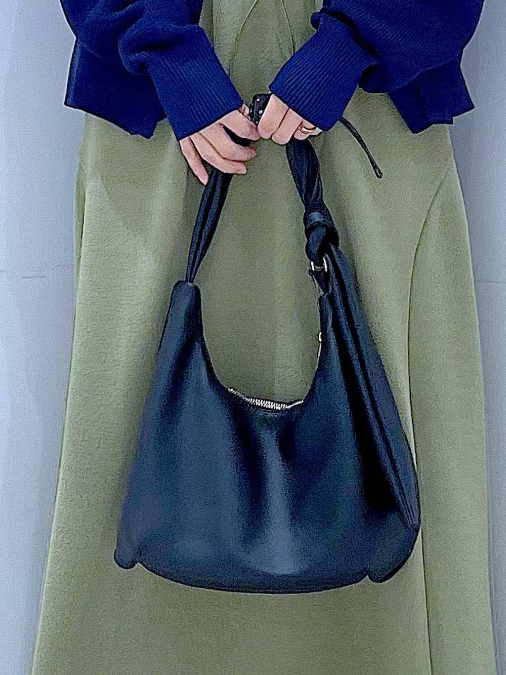 ブラック系のTシャツ/カットソー、ブラック系のショルダーバッグ、グリーン系のスカートを着用したレディースの春コーディネートの9枚目の写真