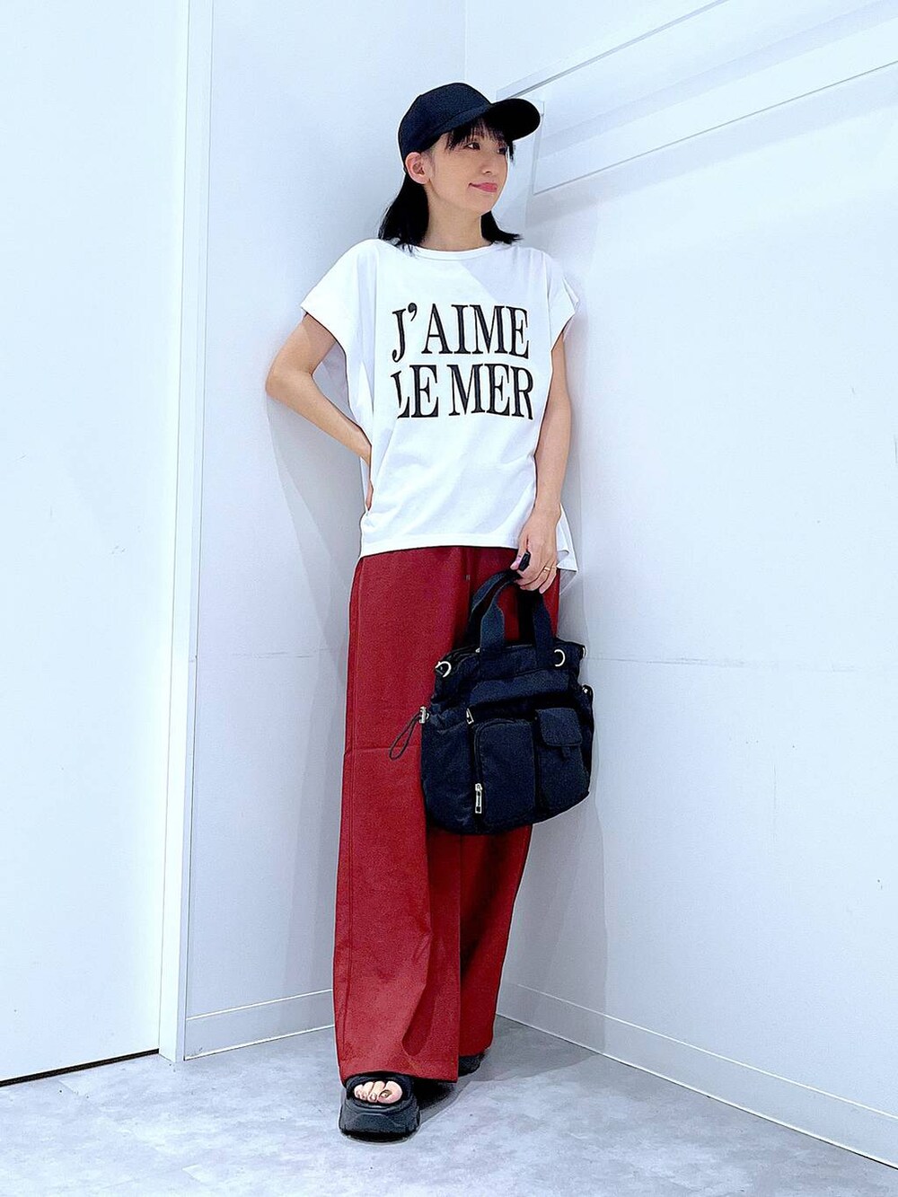ホワイト系のTシャツ/カットソー、ブラック系のトートバッグ、ブラウン系のその他パンツを着用したレディースの夏コーディネートの2枚目の写真