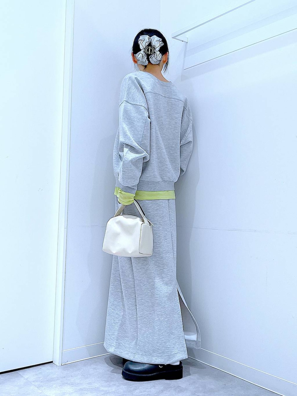 グリーン系のTシャツ/カットソー、ホワイト系のショルダーバッグ、ブラック系のサンダルを着用したレディースの春コーディネートの3枚目の写真