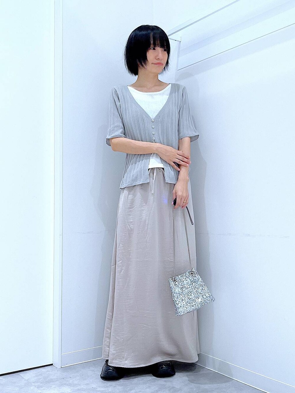 シルバー系のショルダーバッグ、ブラック系のローファー、グレー系のニット/セーターを着用したレディースの秋コーディネートの2枚目の写真