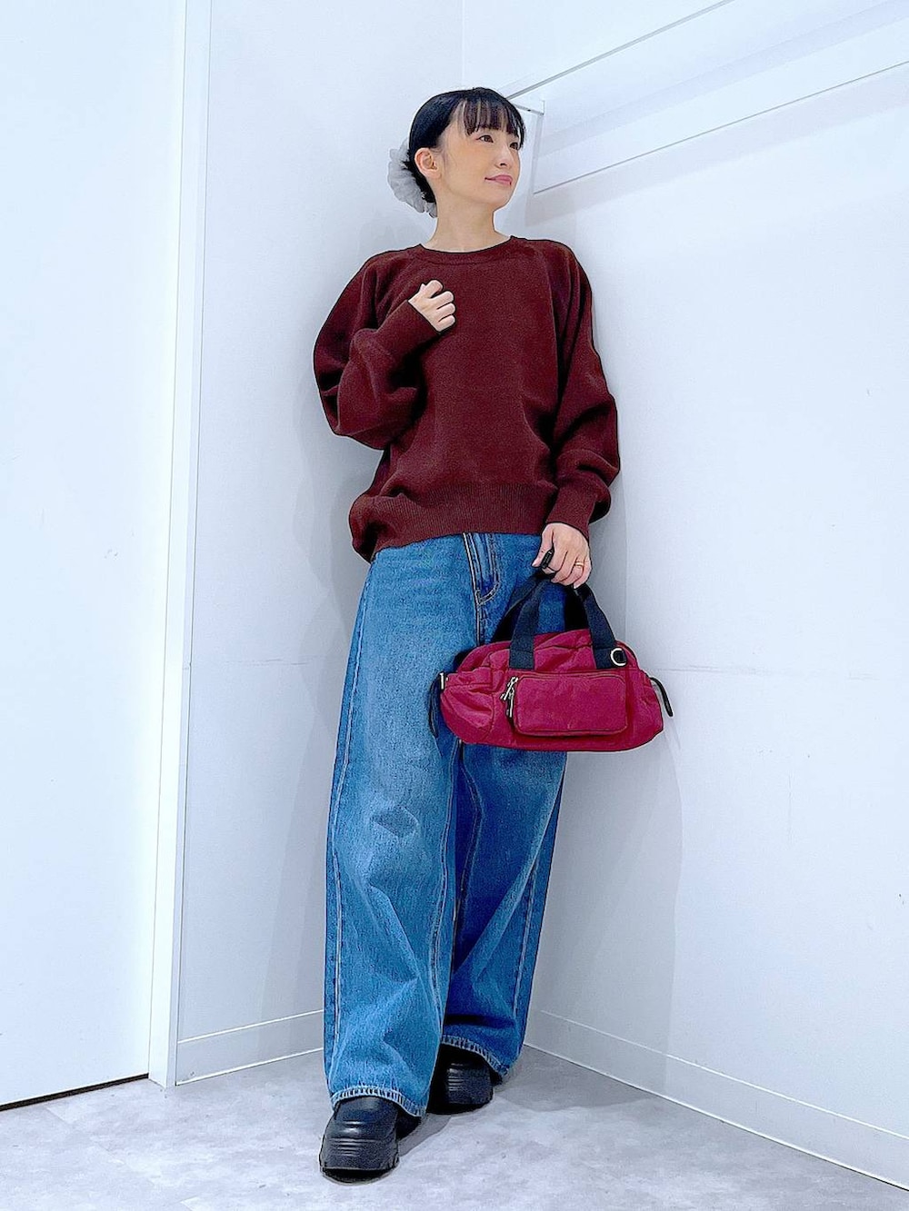 ブルー系のデニムパンツ、ブラウン系のニット/セーター、ブラック系のローファーを着用したレディースの秋コーディネートの2枚目の写真