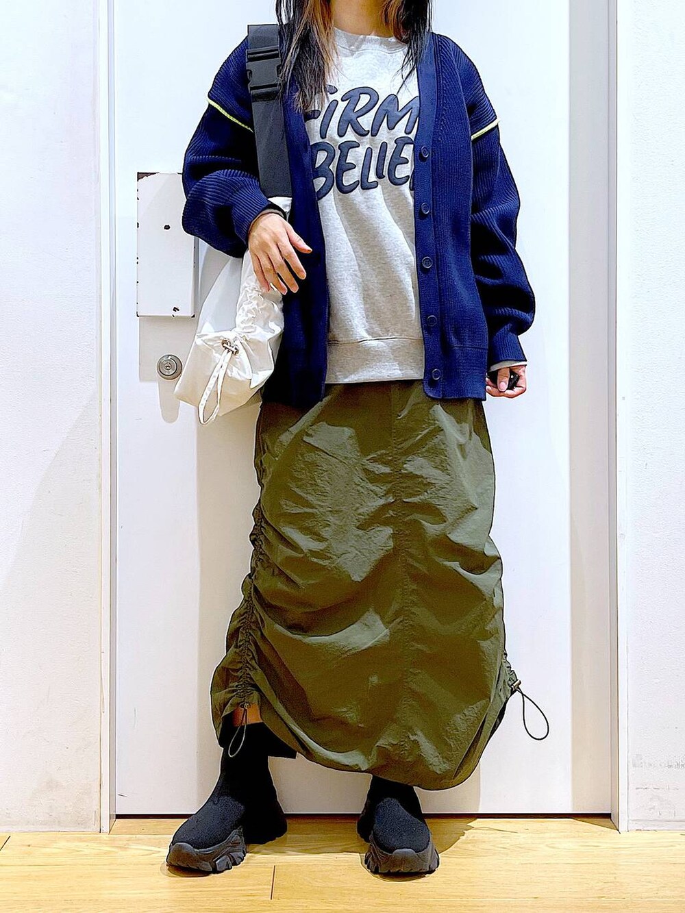 グレー系のスウェット、ブラック系のブーツ、グリーン系のスカートを着用したレディースの冬コーディネートの6枚目の写真