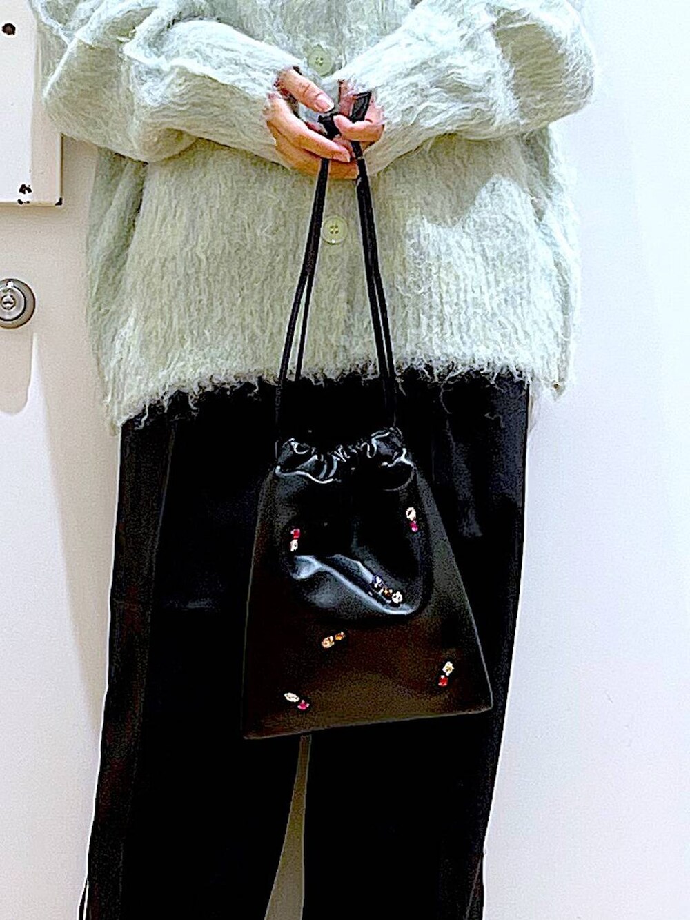 グリーン系のカーディガン/ボレロ、ブラック系のスラックス、ブラック系のショルダーバッグを着用したレディースの冬コーディネートの9枚目の写真