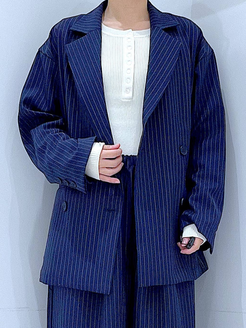 ブラック系のブーツ、ブラック系のショルダーバッグ、ブルー系のスラックスを着用したレディースの冬コーディネートの7枚目の写真