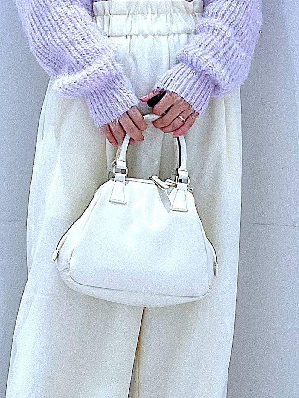 ブラック系のブーツ、ホワイト系のショルダーバッグ、パープル系のニット/セーターを着用したレディースの冬コーディネートの9枚目の写真