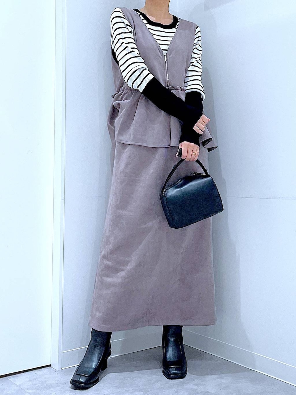 ブラック系のブーツ、グレー系のワンピース、ブラック系のショルダーバッグを着用したレディースの冬コーディネートの6枚目の写真