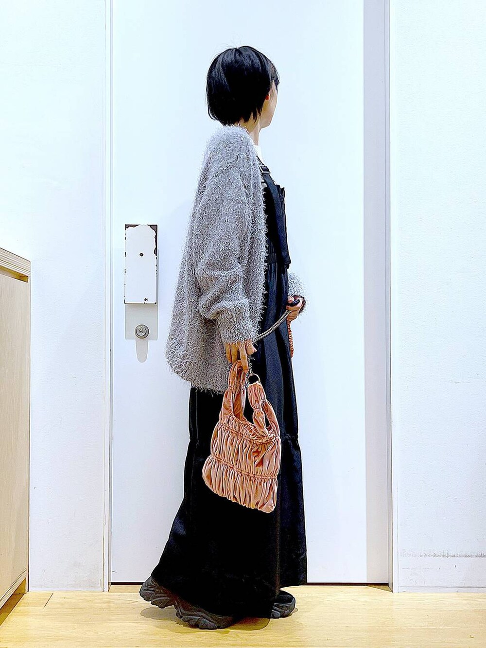 ホワイト系のニット/セーター、ピンク系のショルダーバッグ、グレー系のカーディガン/ボレロを着用したレディースの冬コーディネートの4枚目の写真