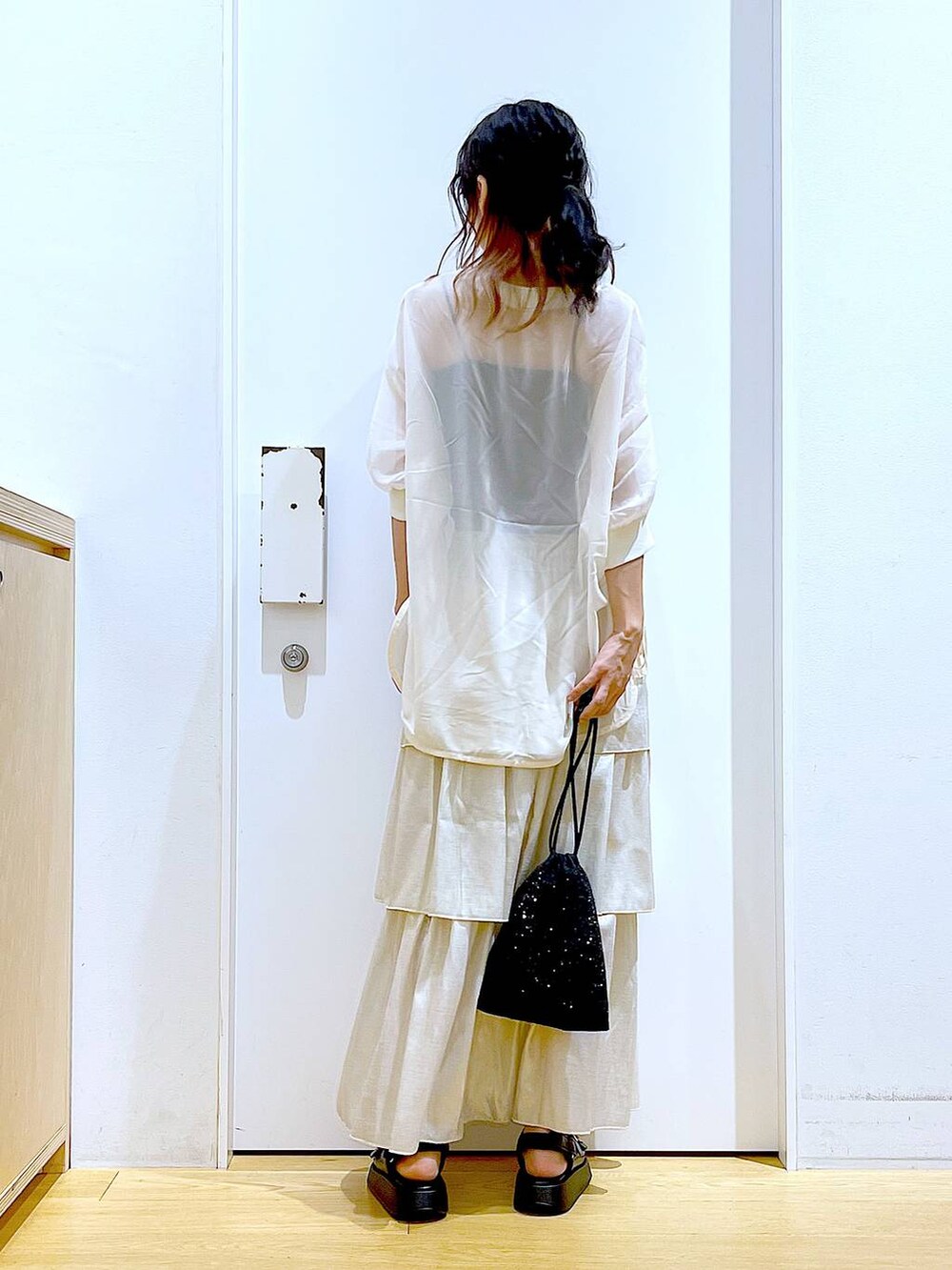 ブラック系のサンダル、ブラック系のショルダーバッグ、ゴールド系のスカートを着用したレディースの夏コーディネートの5枚目の写真