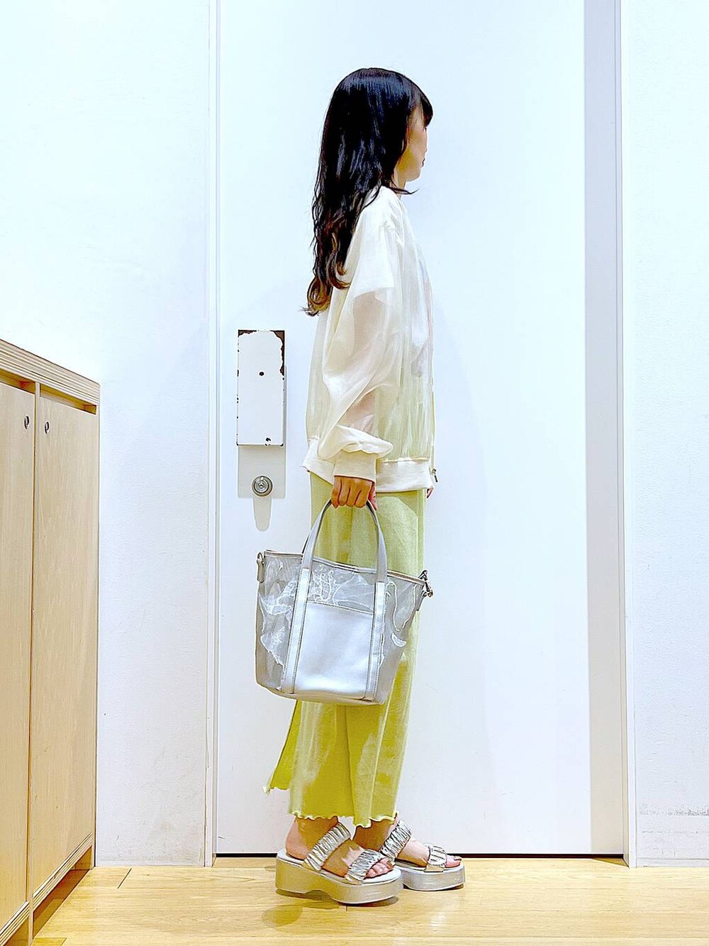 グリーン系のスカート、シルバー系のサンダル、シルバー系のトートバッグを着用したレディースの夏コーディネートの4枚目の写真