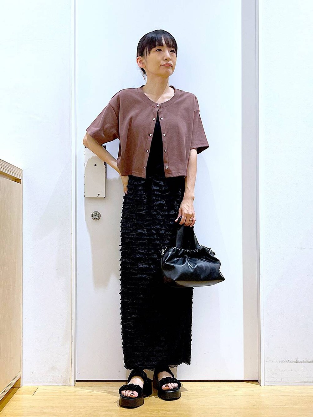 レッド系のワンピース、ブラック系のサンダル、ブラック系のショルダーバッグを着用したレディースの夏コーディネートの2枚目の写真