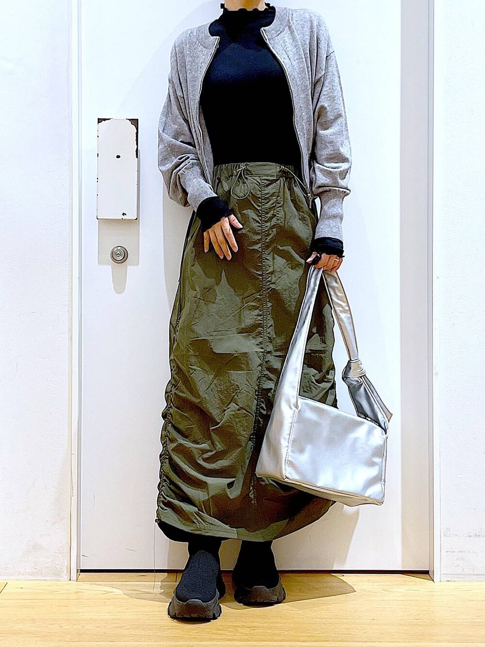 ブラック系のTシャツ/カットソー、グレー系のカーディガン/ボレロ、ブラック系のブーツを着用したレディースの冬コーディネートの6枚目の写真