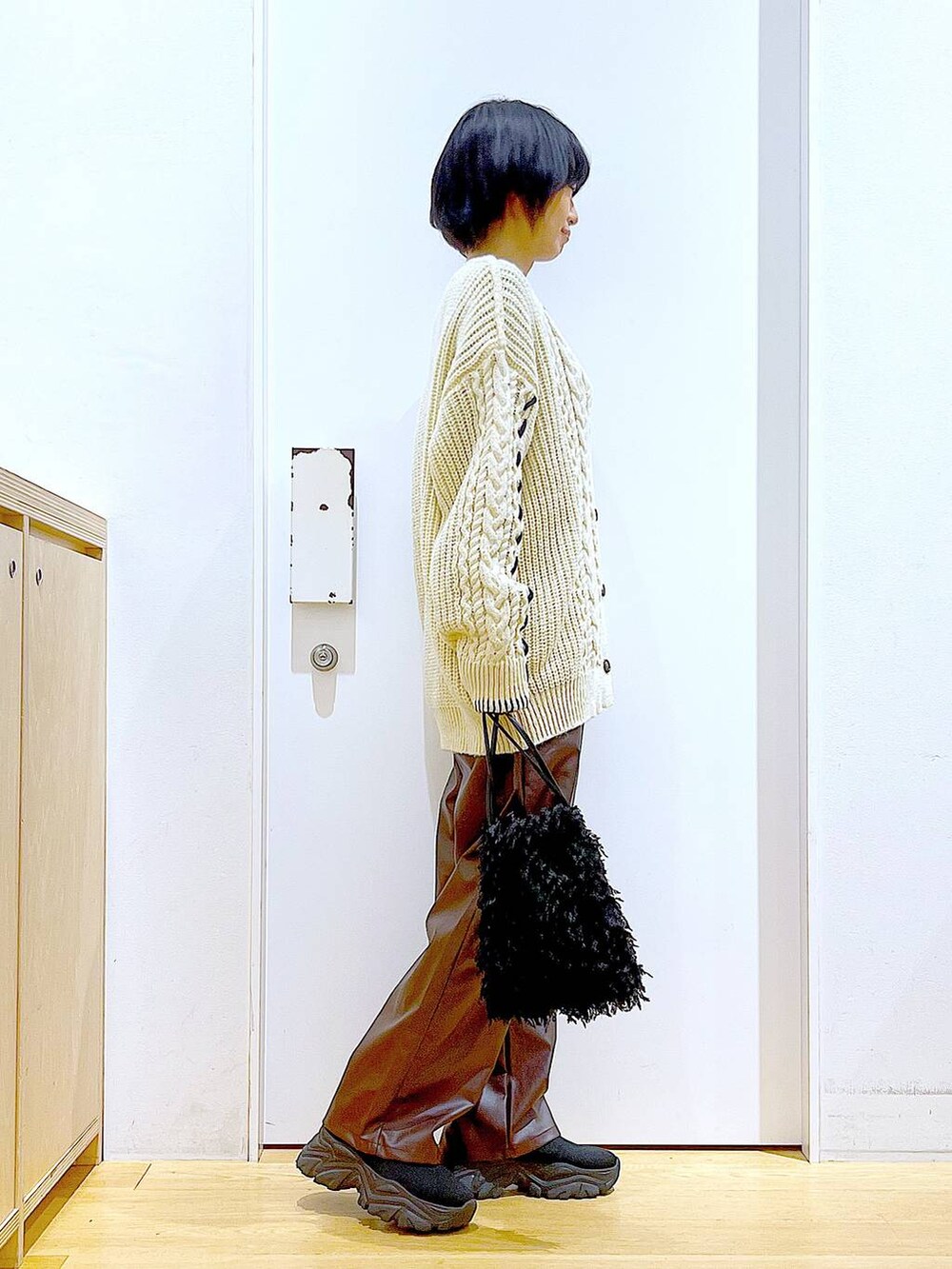 ブラック系のショルダーバッグ、グレー系のTシャツ/カットソー、ブラック系のブーツを着用したレディースの秋コーディネートの4枚目の写真