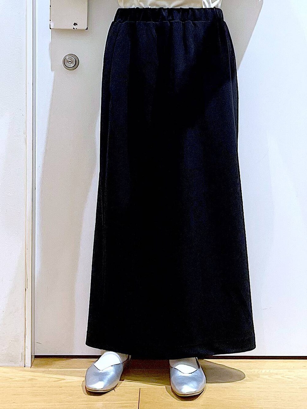 ブラック系のトートバッグ、シルバー系のパンプス、ブラック系のスカートを着用したレディースの春コーディネートの8枚目の写真