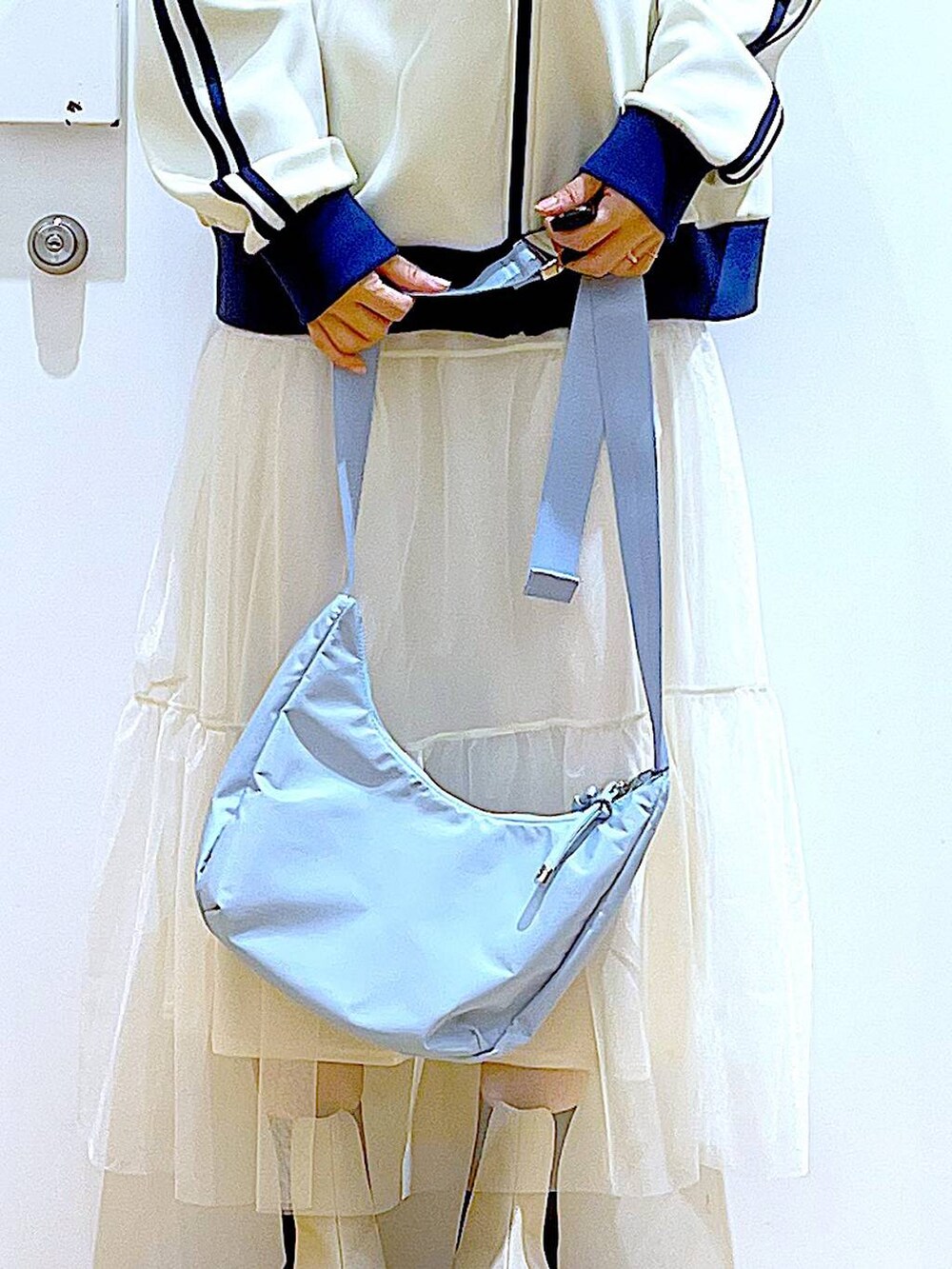 ベージュ系のブーツ、ブルー系のショルダーバッグ、ベージュ系のスウェットを着用したレディースの春コーディネートの9枚目の写真