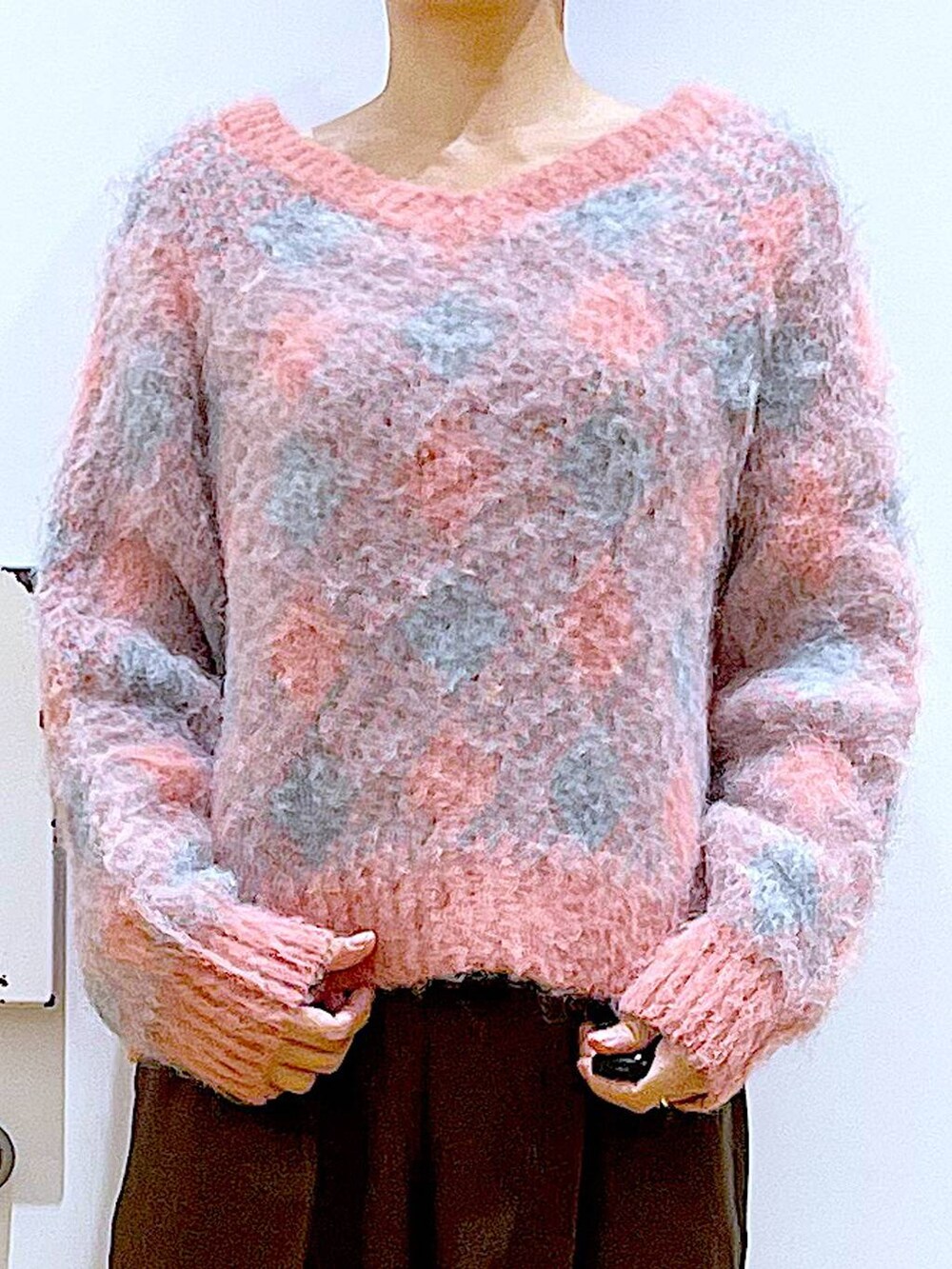 ブラック系のブーツ、ブラック系のショルダーバッグ、ピンク系のニット/セーターを着用したレディースの冬コーディネートの7枚目の写真