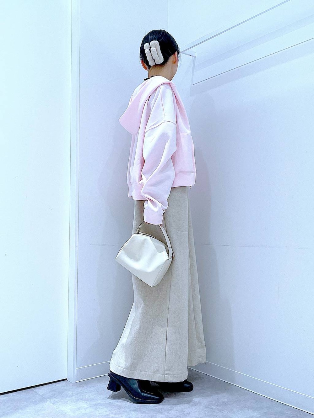 ブラック系のブーツ、ベージュ系のジャンパースカート、ブラック系のTシャツ/カットソーを着用したレディースの冬コーディネートの4枚目の写真