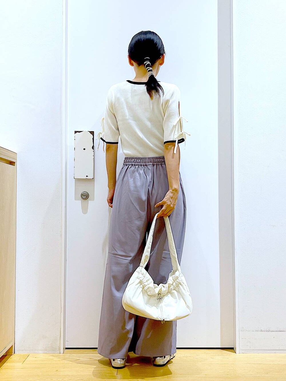 ホワイト系のハンドバッグ、グレー系のその他パンツ、シルバー系のパンプスを着用したレディースの秋コーディネートの5枚目の写真