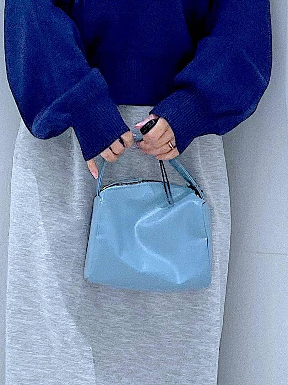 ブルー系のショルダーバッグ、ブラック系のサンダル、グレー系のスカートを着用したレディースの春コーディネートの9枚目の写真