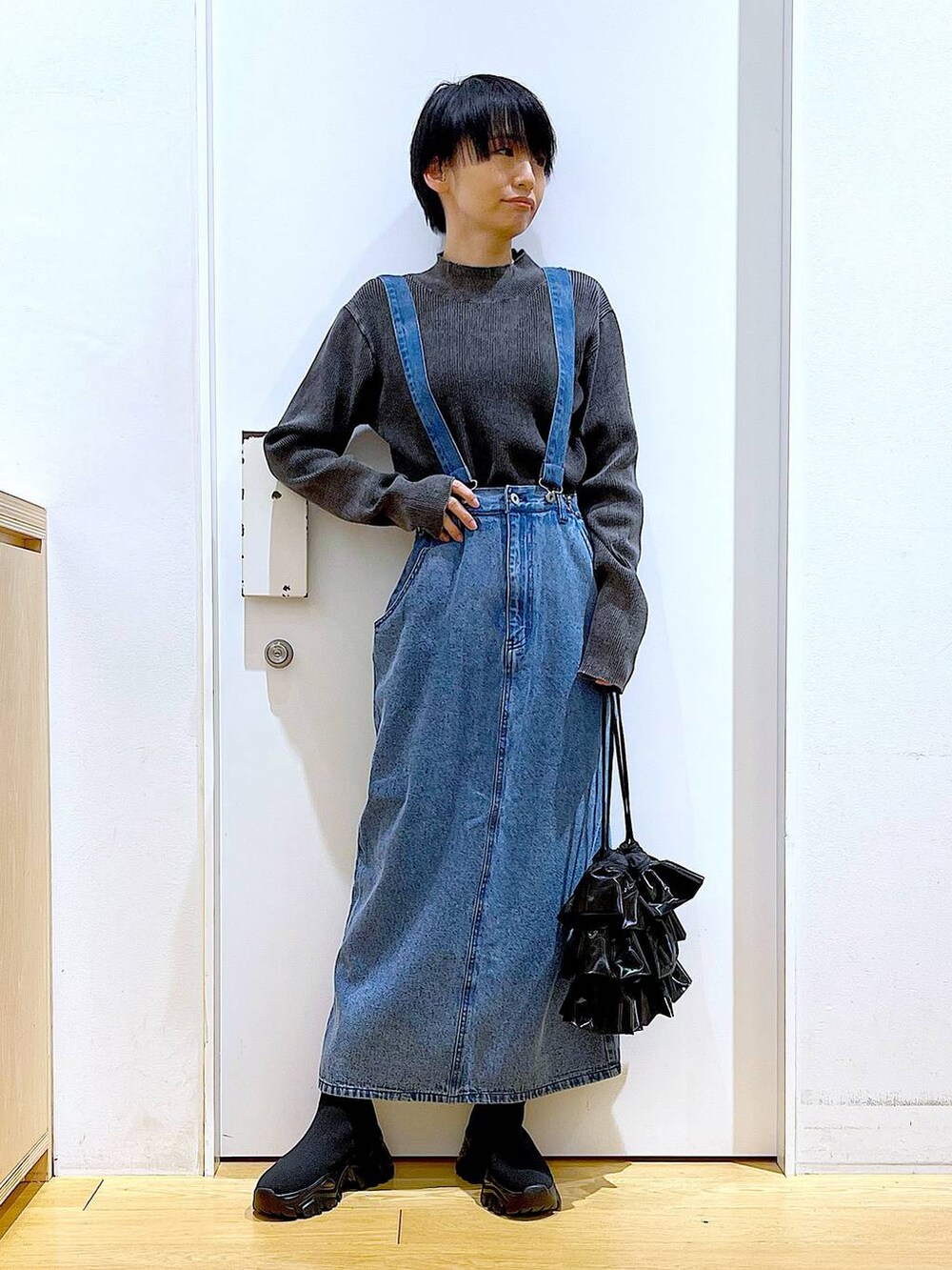 ブラック系のブーツ、ブラック系のショルダーバッグ、ブラック系のニット/セーターを着用したレディースの春コーディネートの2枚目の写真