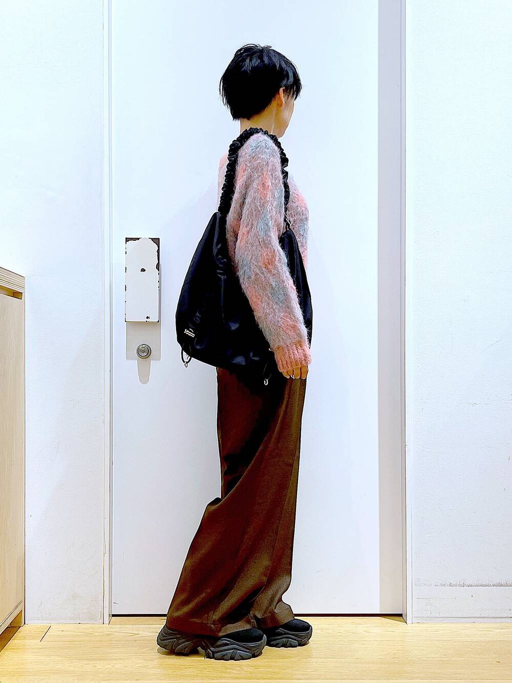 ブラック系のブーツ、ブラック系のショルダーバッグ、ピンク系のニット/セーターを着用したレディースの冬コーディネートの4枚目の写真