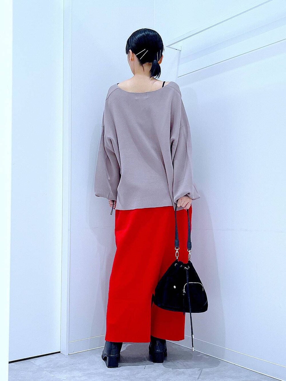 ブラウン系のニット/セーター、ブラック系のショルダーバッグ、ブラック系のブーツを着用したレディースの冬コーディネートの5枚目の写真