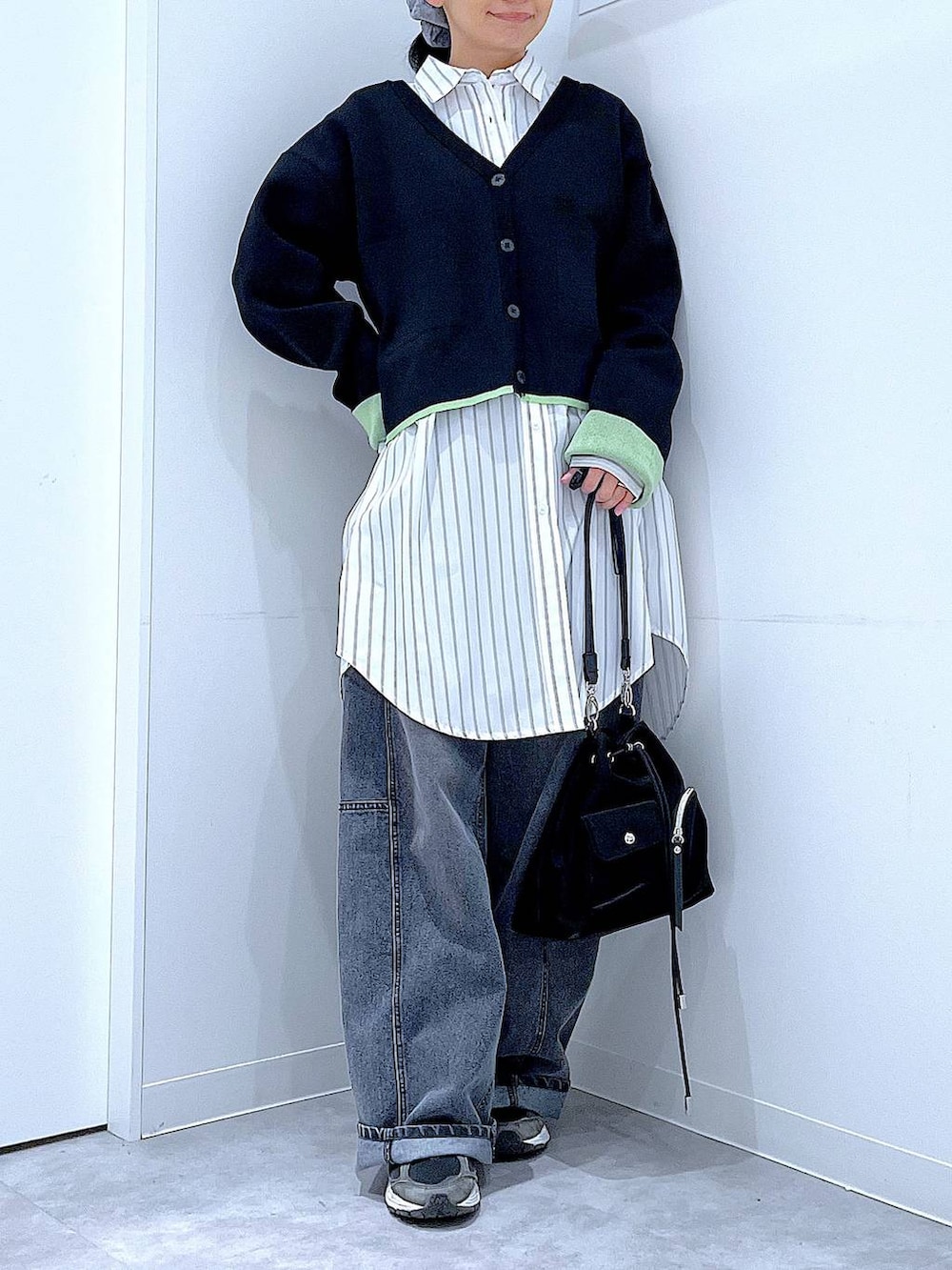 ブラック系のショルダーバッグ、ブラック系のデニムパンツ、ホワイト系のシャツ/ブラウスを着用したレディースの春コーディネートの6枚目の写真