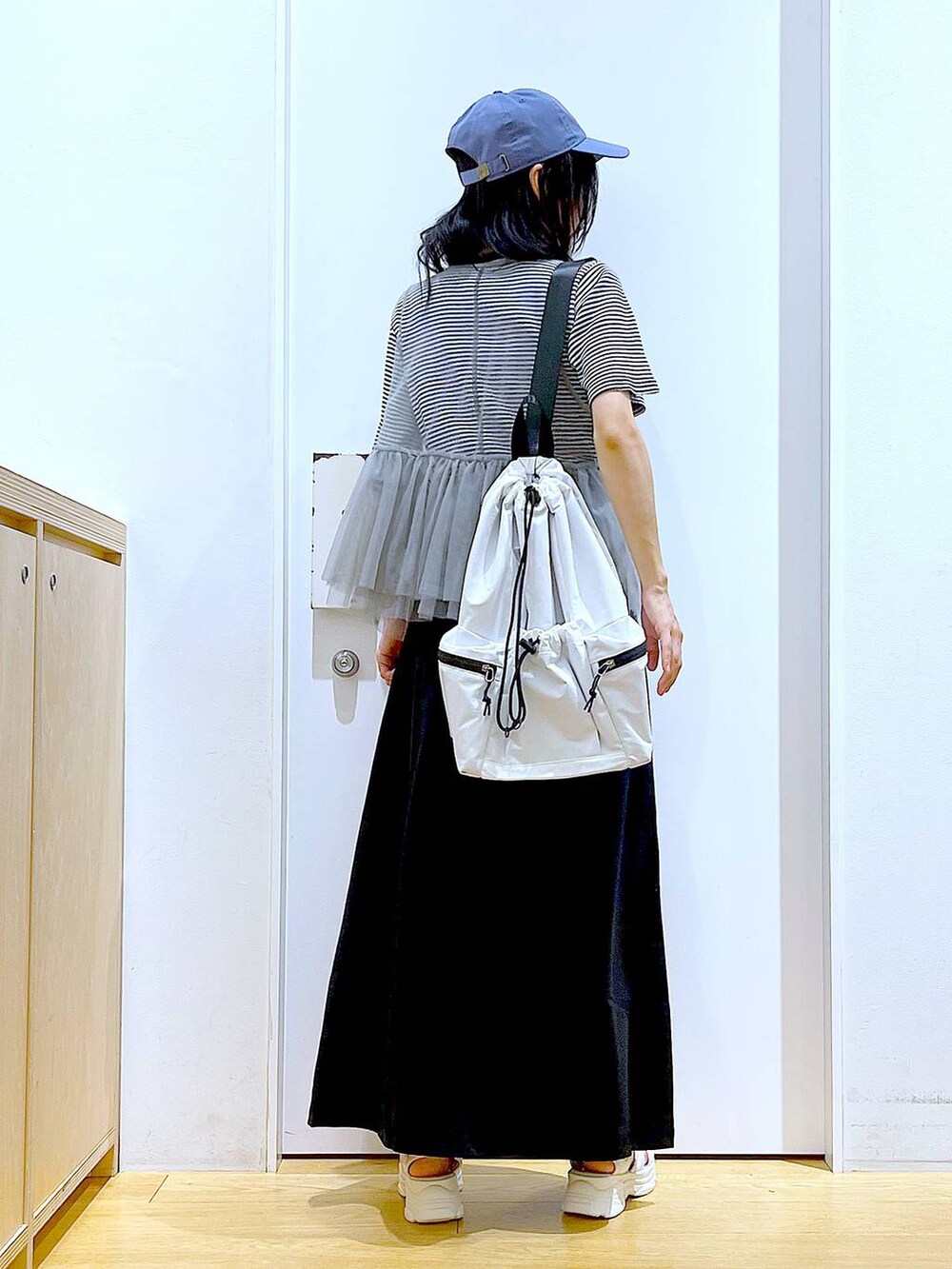 ホワイト系のショルダーバッグ、ホワイト系のサンダル、ブラック系のスカートを着用したレディースの夏コーディネートの5枚目の写真