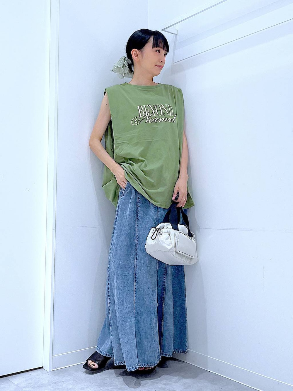 ブラック系のサンダル、ホワイト系のショルダーバッグ、グリーン系のTシャツ/カットソーを着用したレディースの夏コーディネートの2枚目の写真