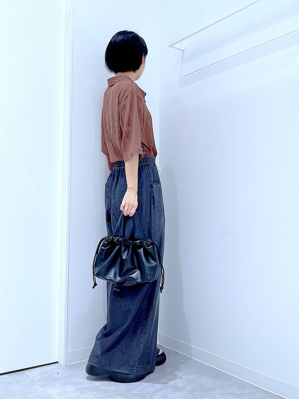 ブラウン系のシャツ/ブラウス、ブラック系のショルダーバッグ、ブラック系のデニムパンツを着用したレディースの夏コーディネートの4枚目の写真