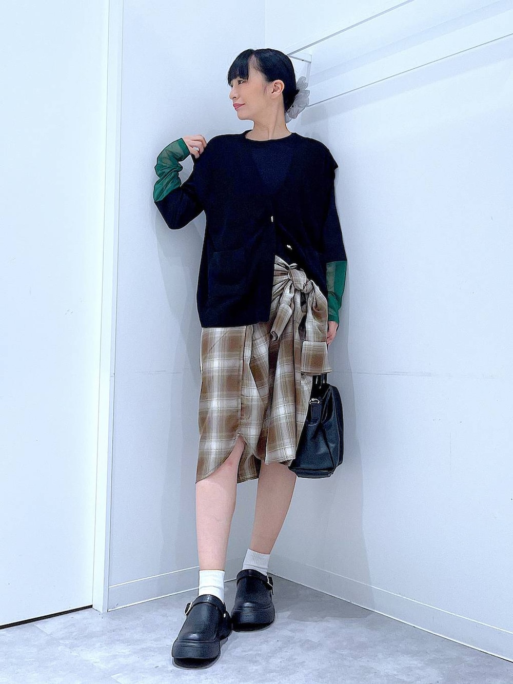 ブラウン系のシャツ/ブラウス、ブラック系のTシャツ/カットソー、ブラック系のハンドバッグを着用したレディースの秋コーディネートの2枚目の写真