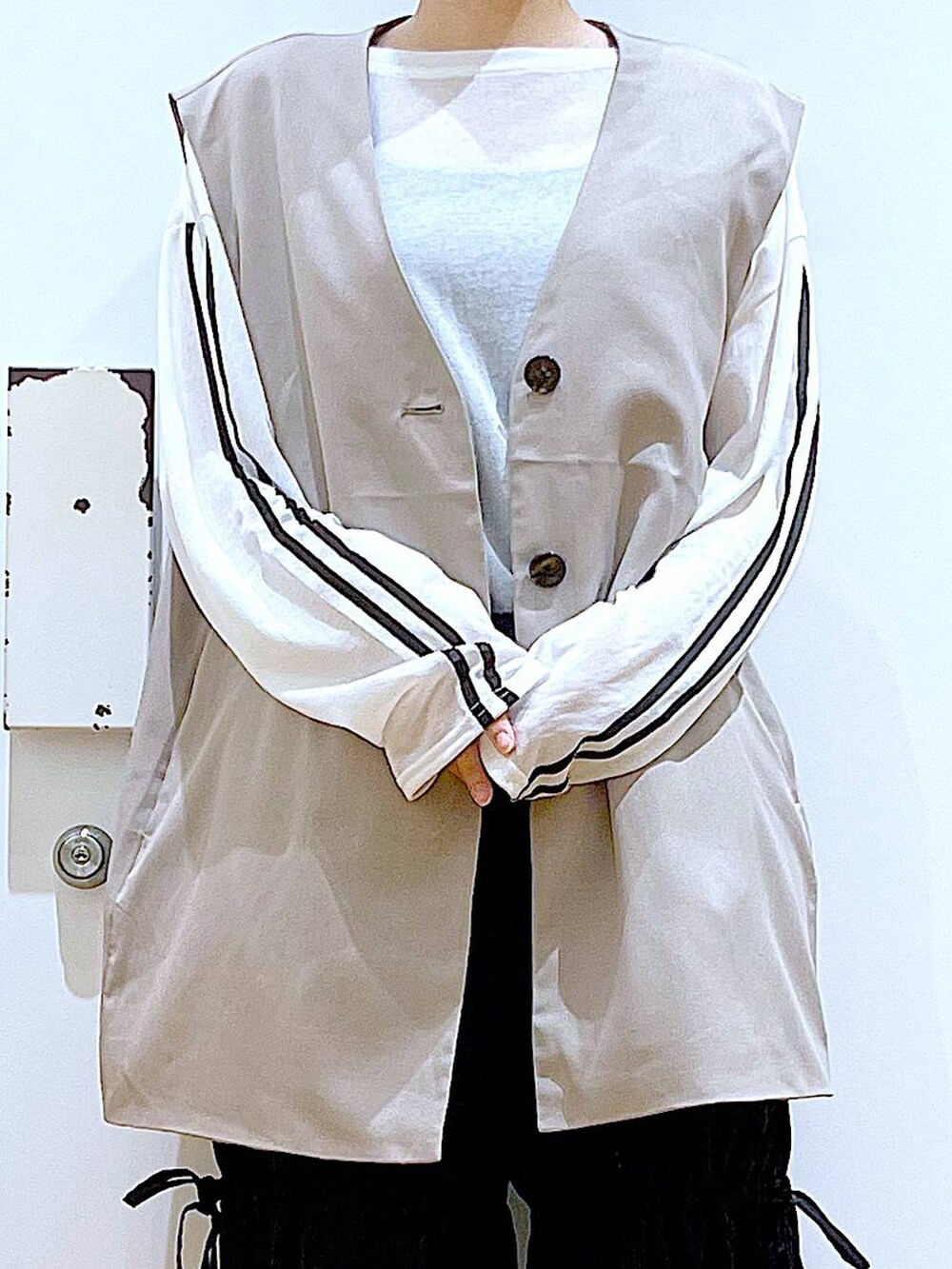 ブラック系のショルダーバッグ、ホワイト系のパンプス、ブラック系のその他パンツを着用したレディースの秋コーディネートの7枚目の写真