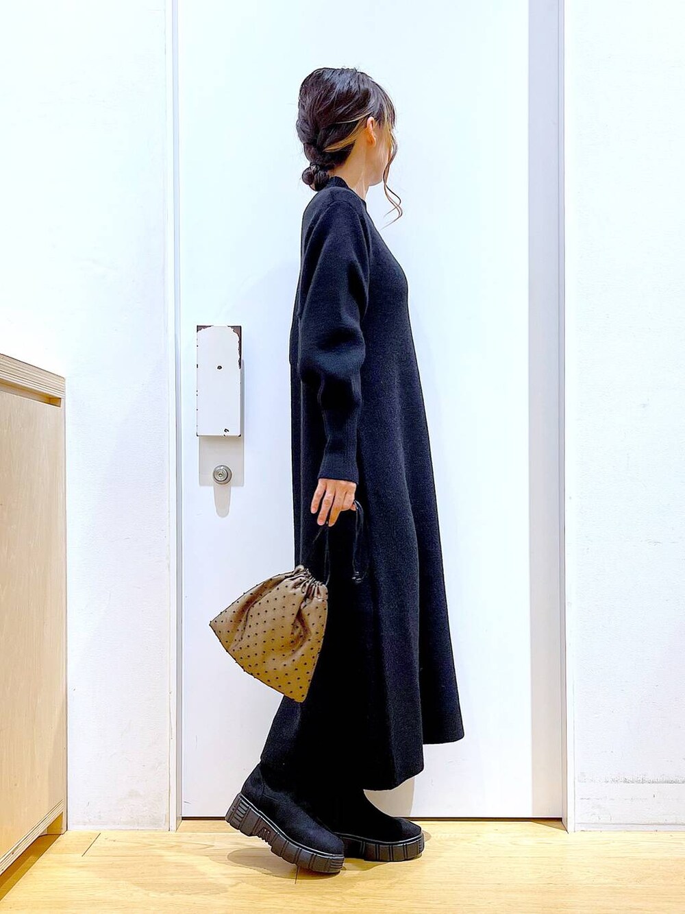 ブラック系のブーツ、ブラック系のワンピース、その他のポーチを着用したレディースの冬コーディネートの4枚目の写真