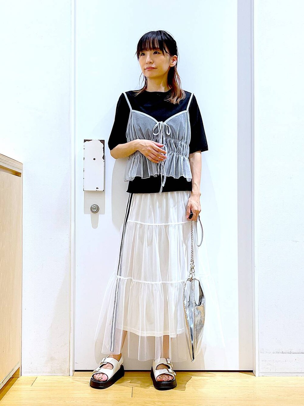 シルバー系のショルダーバッグ、ホワイト系のサンダル、ホワイト系のキャミソールを着用したレディースの夏コーディネートの2枚目の写真