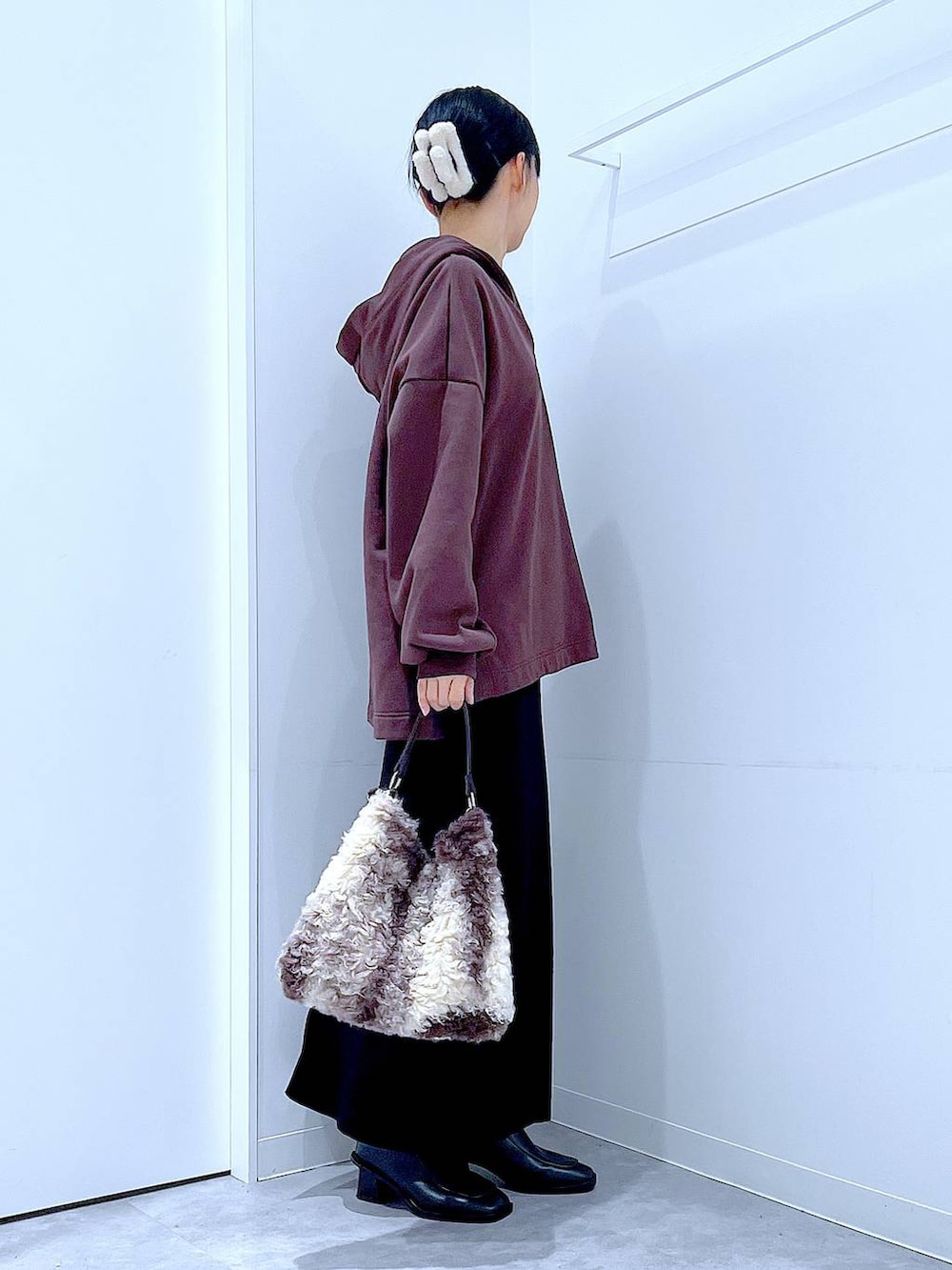 ブラック系のブーツ、ブラウン系のショルダーバッグ、ブラック系のスカートを着用したレディースの冬コーディネートの4枚目の写真