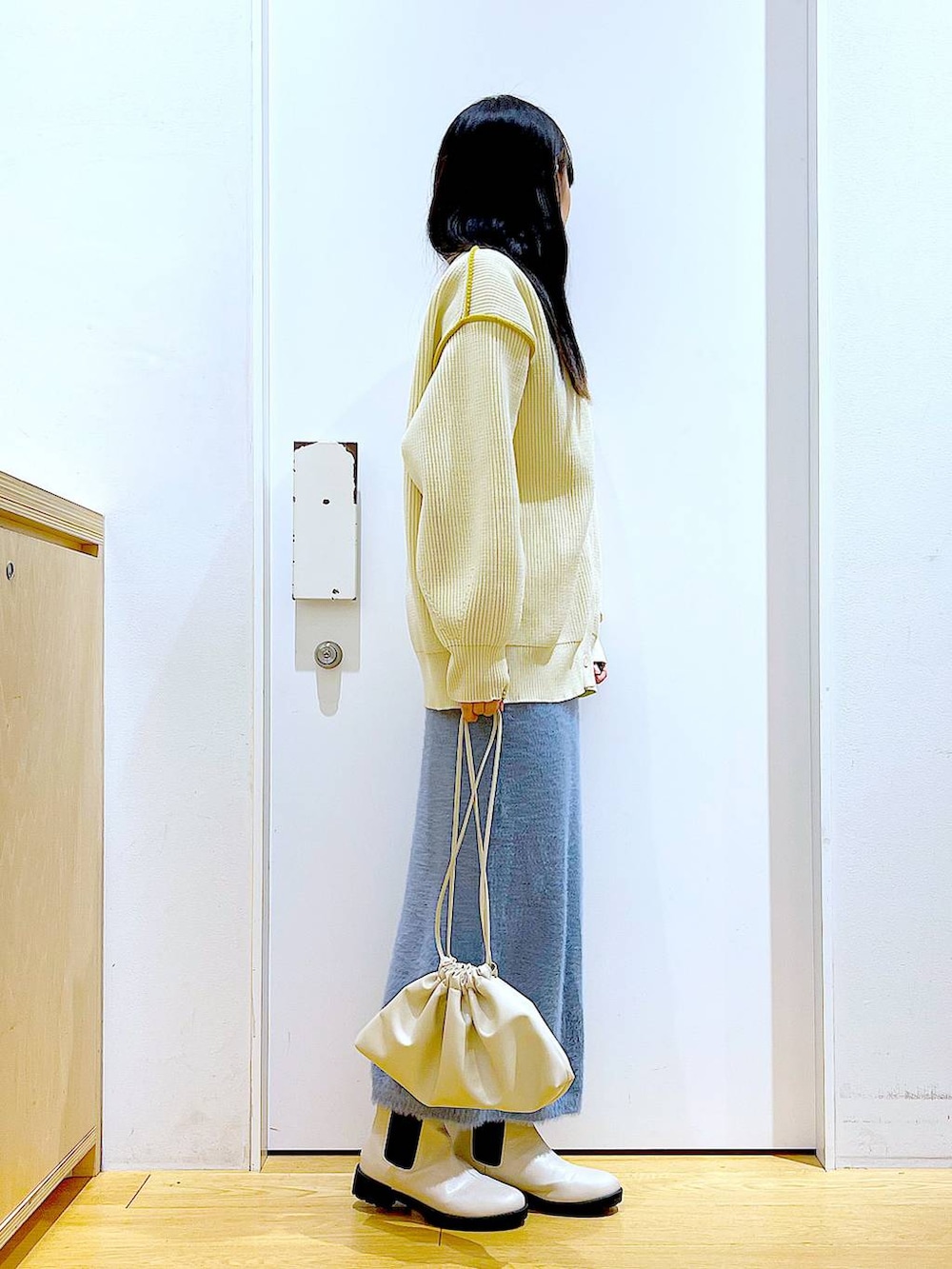 ベージュ系のブーツ、ベージュ系のニット/セーター、ベージュ系のショルダーバッグを着用したレディースの冬コーディネートの4枚目の写真