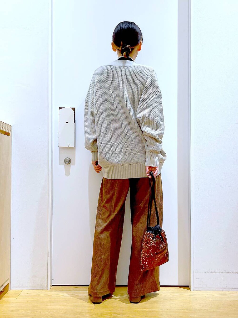 グレー系のカーディガン/ボレロ、ブラック系のニット/セーター、ブラウン系のショルダーバッグを着用したレディースの冬コーディネートの5枚目の写真