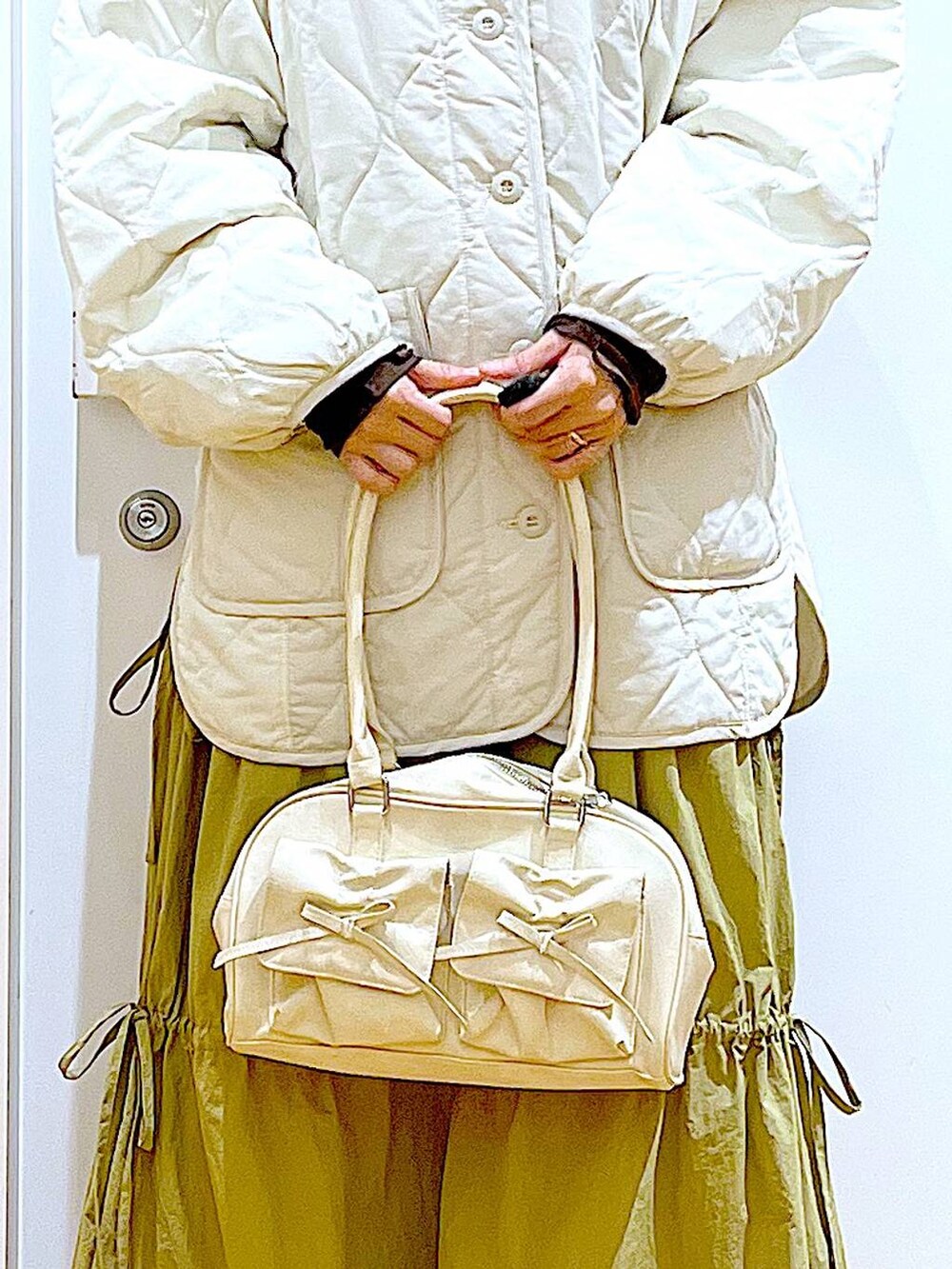 ベージュ系のブルゾン、ベージュ系のスリッポン、ホワイト系のハンドバッグを着用したレディースの秋コーディネートの9枚目の写真