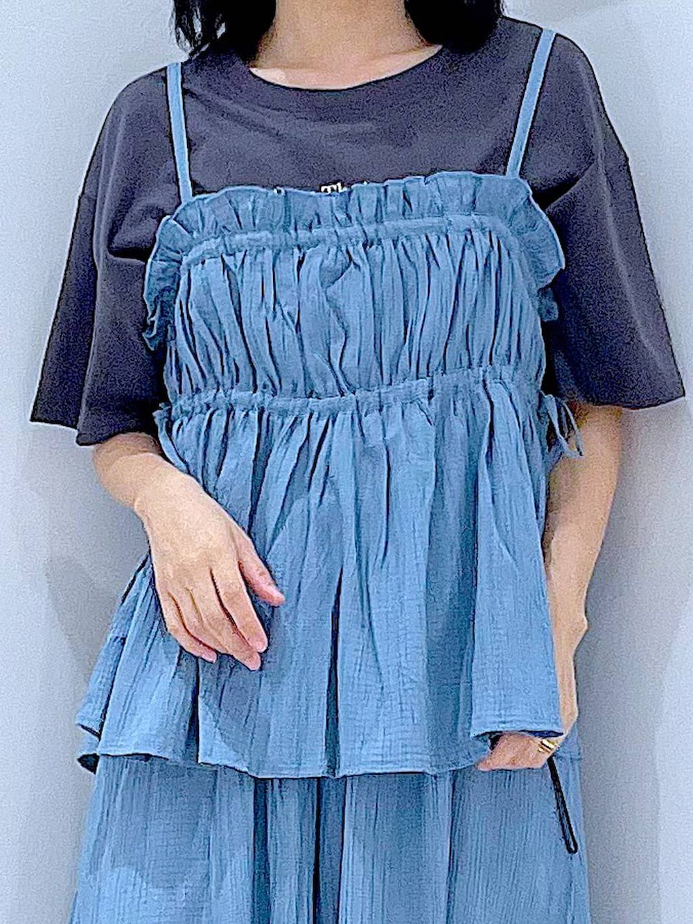 グレー系のTシャツ/カットソー、ブラック系のショルダーバッグ、ブルー系のキャミソールを着用したレディースの夏コーディネートの7枚目の写真