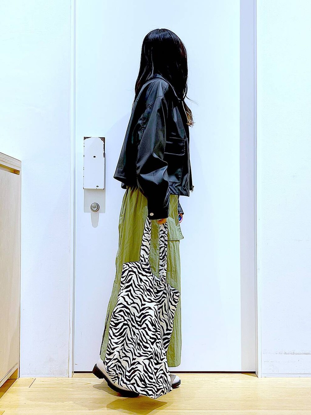 ブラック系のブルゾン、グレー系のスウェット、ベージュ系のブーツを着用したレディースの春コーディネートの4枚目の写真