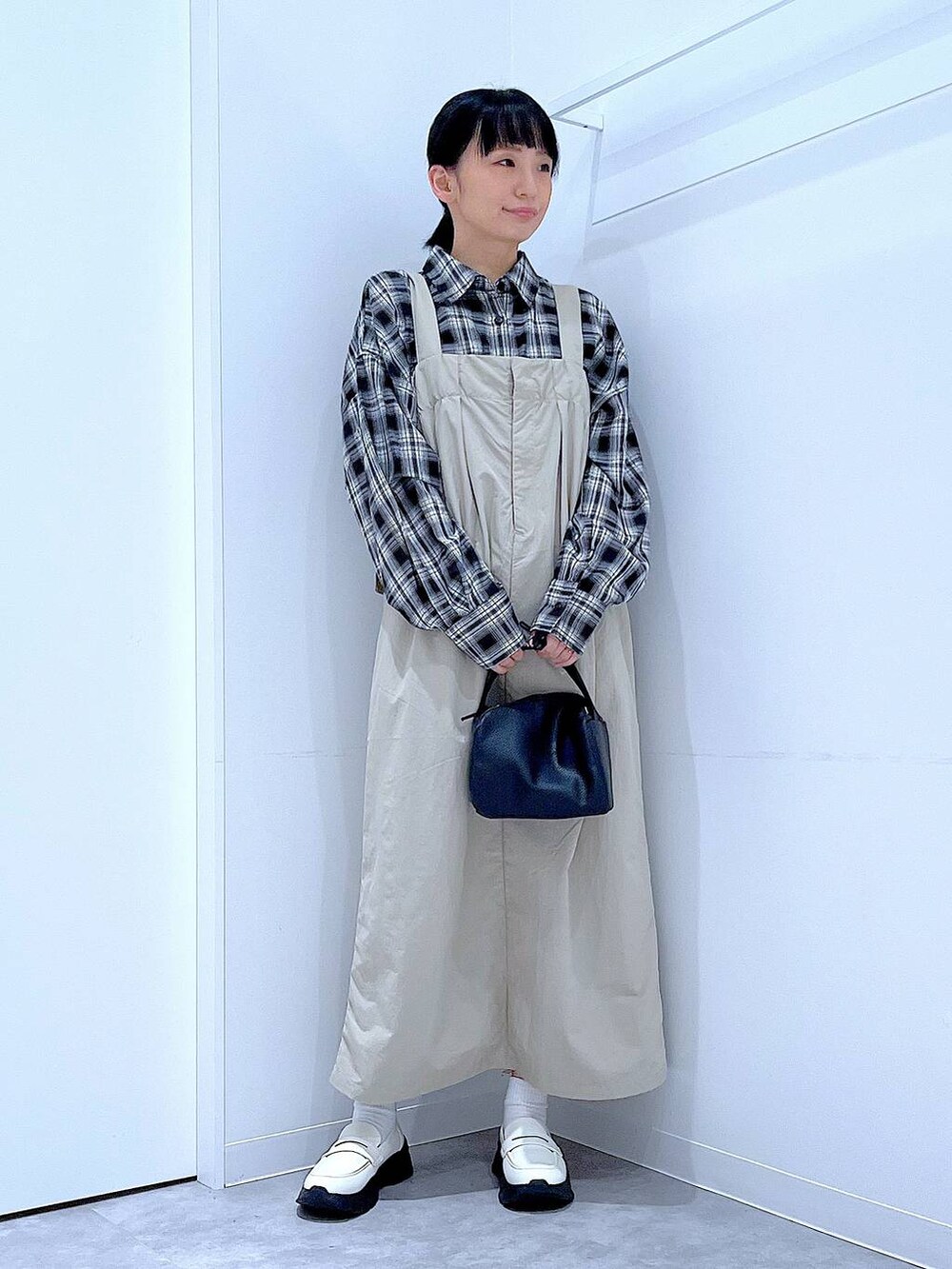 ホワイト系のローファー、ブラック系のショルダーバッグ、グレー系のワンピースを着用したレディースの秋コーディネートの2枚目の写真