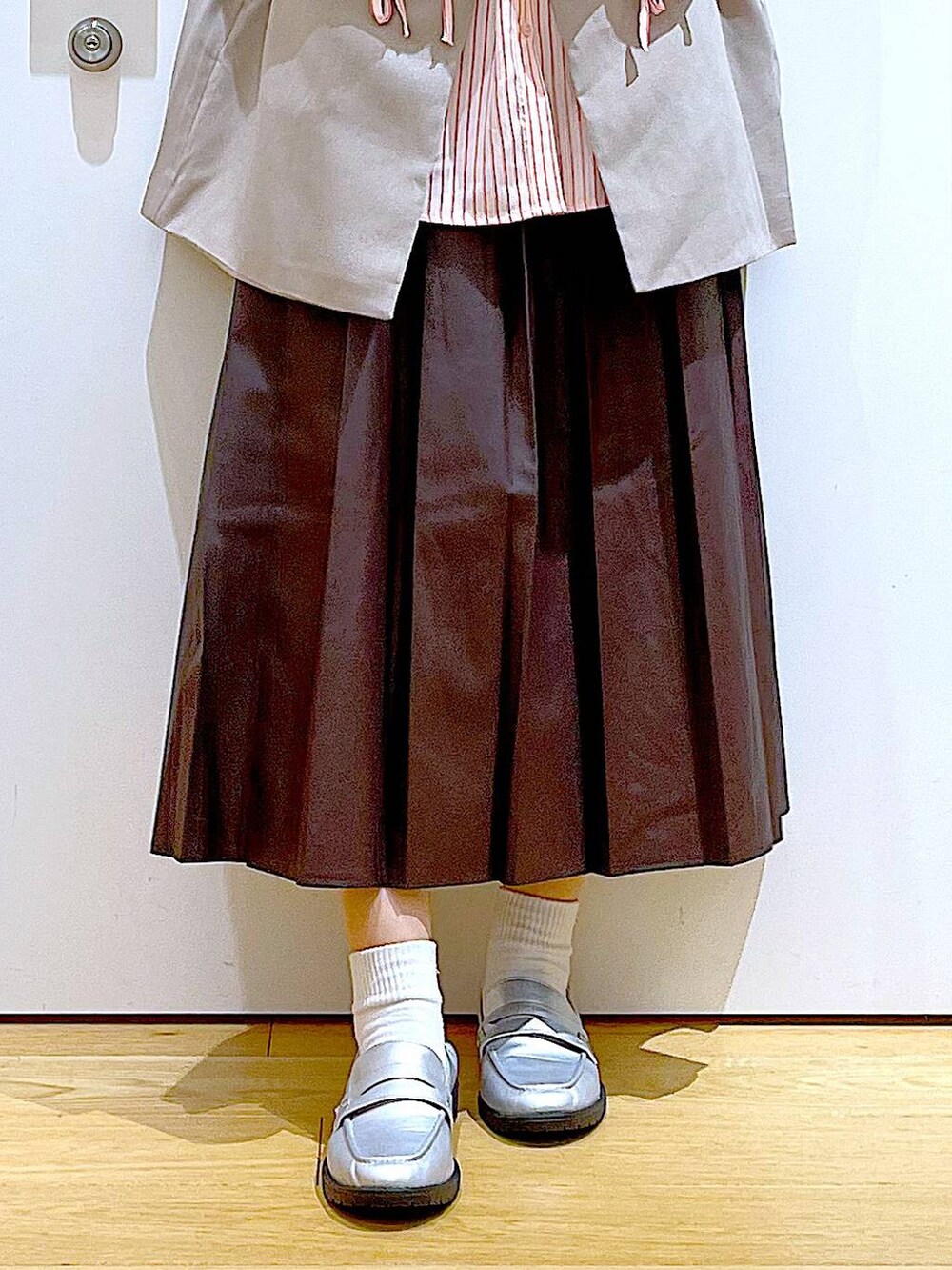 ベージュ系のショルダーバッグ、シルバー系のローファー、ベージュ系のベストを着用したレディースの秋コーディネートの8枚目の写真